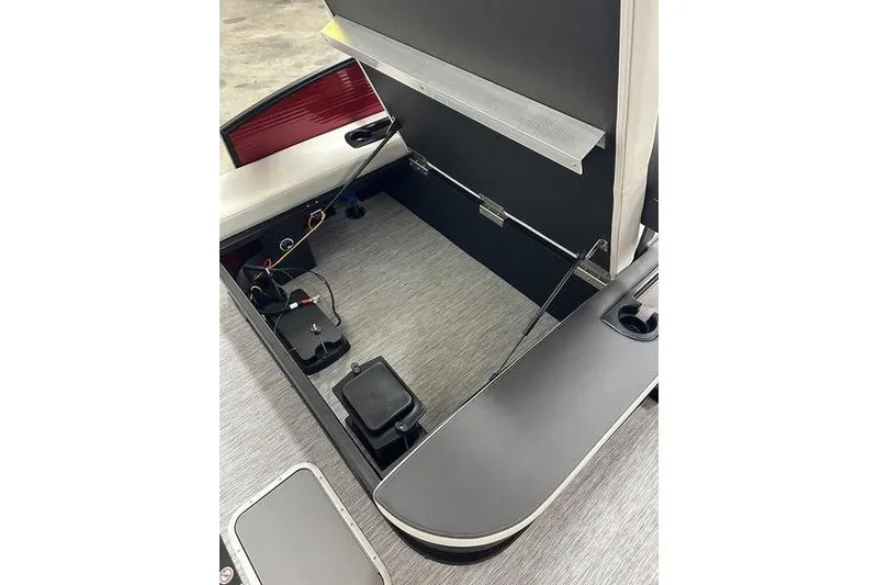 Slide: The Image of 2026 Bennington S Swingback 22 SSB boat storage compartment with open hatch and visible wiring. - 8