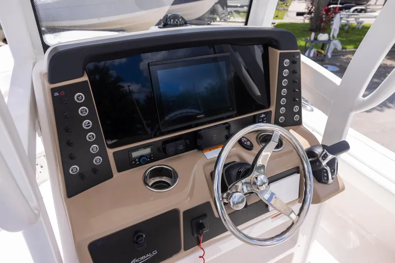 Slide: The Image of 2025 Robalo 246 Cayman boat dashboard with steering wheel and control panel. - 10
