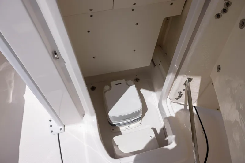 Slide: The Image of 2025 Robalo 246 Cayman boat interior with compact marine toilet. - 13