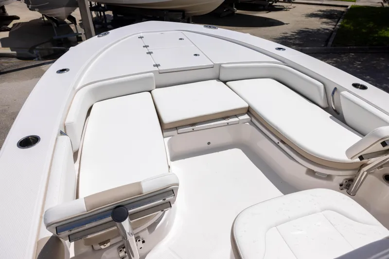 Slide: The Image of 2025 Robalo 246 Cayman boat interior with white cushioned seating. - 14
