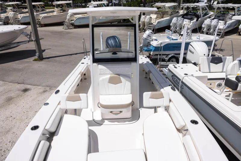 Slide: The Image of 2025 Robalo 246 Cayman boat interior with seating and console, docked among other boats. - 15