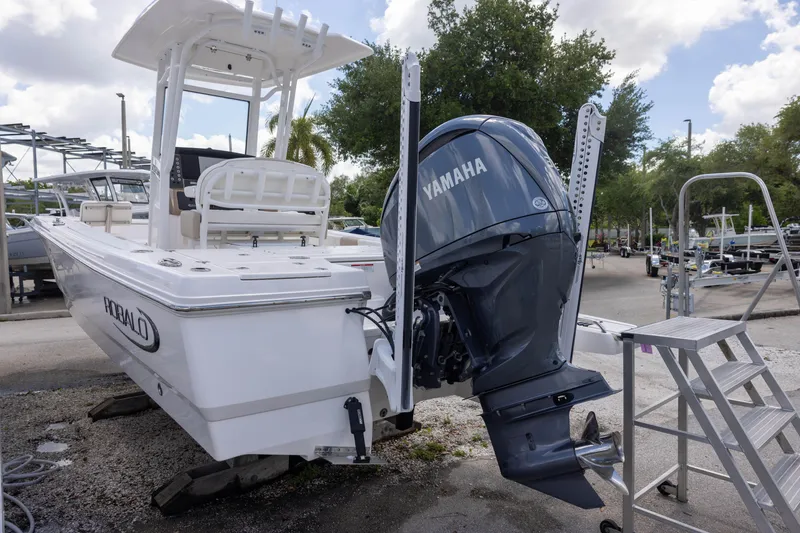 Slide: The Image of 2025 Robalo 246 Cayman boat with Yamaha engine, parked outdoors. - 2