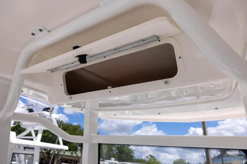 Slide: The Image of 2025 Robalo 246 Cayman boat storage compartment under clear blue sky. - 6