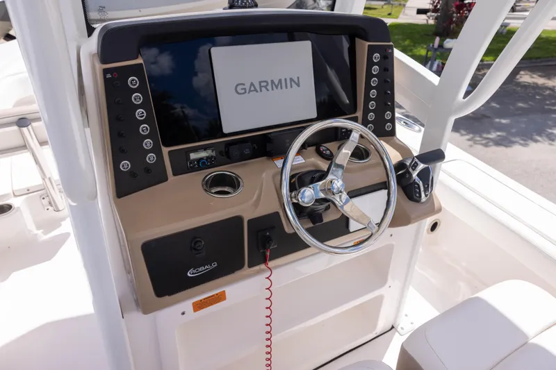 Slide: The Image of 2025 Robalo 246 Cayman boat dashboard with Garmin navigation system and steering wheel. - 9