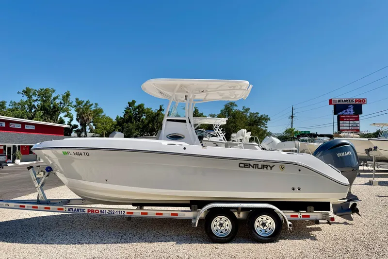 The Image of 2022 Century 2301 Center Console boat on trailer, displayed outdoors under clear blue sky. - 0
