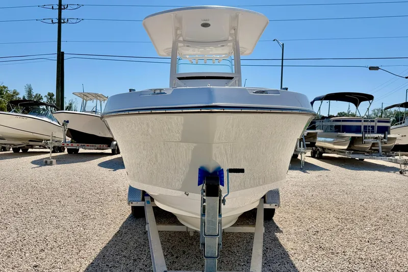 Slide: The Image of 2022 Century 2301 Center Console boat on display in a gravel lot. - 2