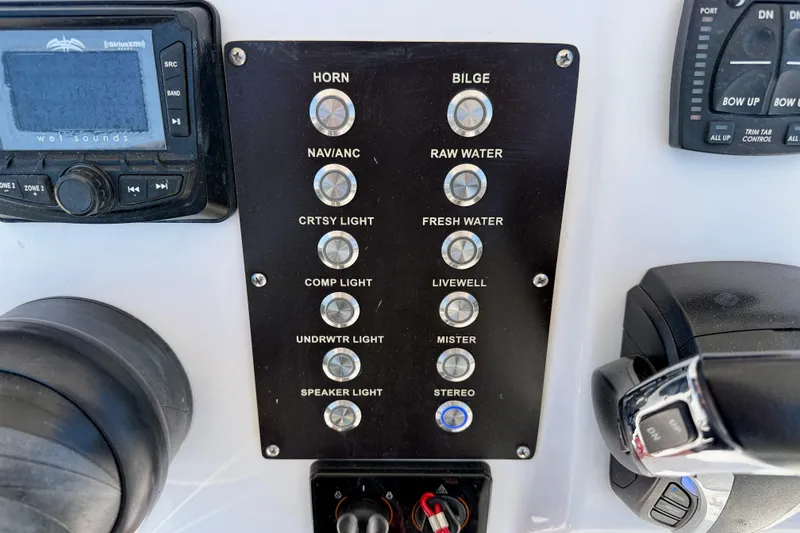 Slide: The Image of Control panel of a 2022 Century 2301 Center Console boat with various switches and controls. - 22