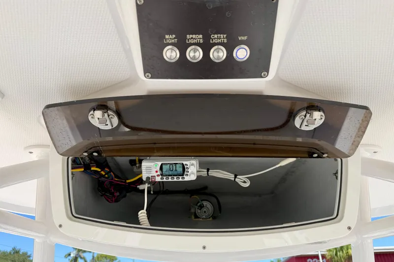 Slide: The Image of Century 2301 Center Console 2022 boat dashboard with control panel and VHF radio. - 23