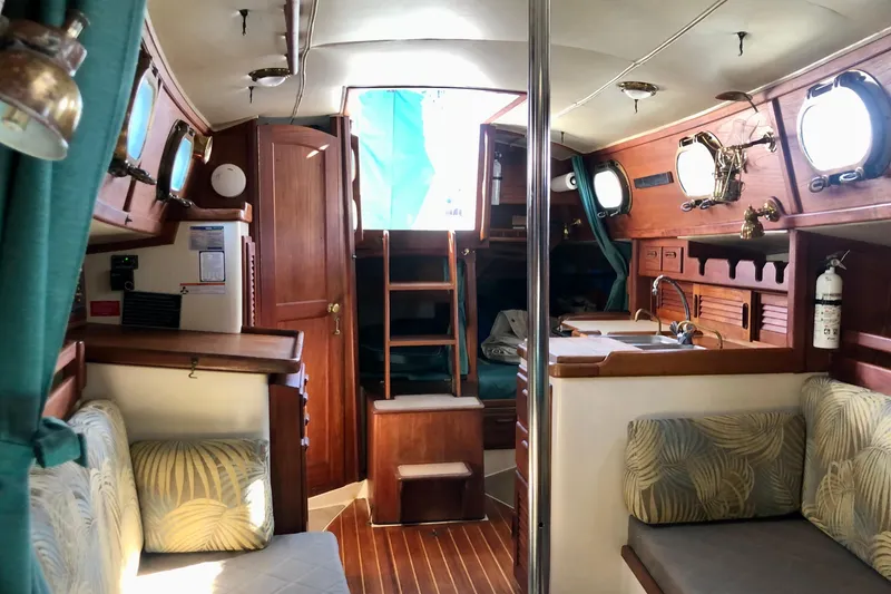 Slide: The Image of Interior of a 1988 Pacific Seacraft 31 sailboat with wooden finishes and cozy seating. - 10