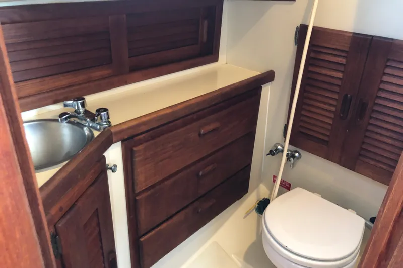 Slide: The Image of 1988 Pacific Seacraft 31 yacht bathroom with wooden cabinets and compact sink. - 11