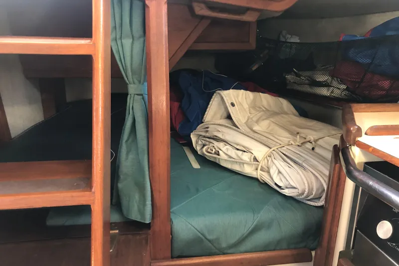 Slide: The Image of Interior cabin of 1988 Pacific Seacraft 31 sailboat with folded sails and wooden furnishings. - 12