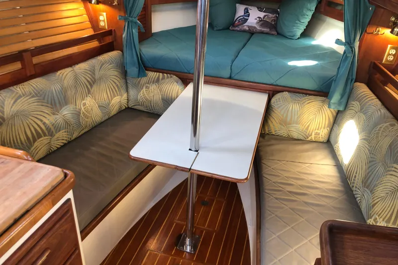 Slide: The Image of Cozy interior of a 1988 Pacific Seacraft 31 sailboat with seating and a table. - 5