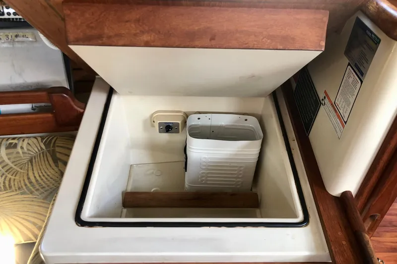 Slide: The Image of Interior storage compartment of a 1988 Pacific Seacraft 31 sailboat, featuring a white container. - 9