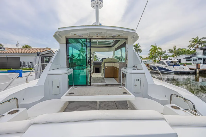 Slide: The Image of 2012 Cruisers Yachts 48 Cantius, rear view, docked with open cabin and seating area. - 12