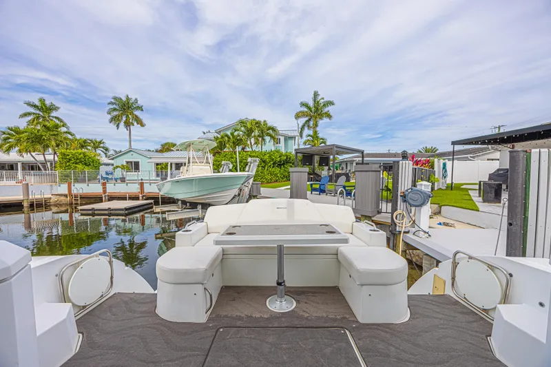 Slide: The Image of 2012 Cruisers Yachts 48 Cantius docked, featuring spacious seating and scenic waterfront view. - 15