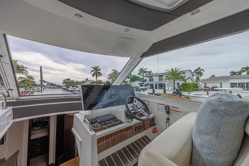 Slide: The Image of Interior view of 2012 Cruisers Yachts 48 Cantius helm with modern controls and waterfront backdrop. - 26