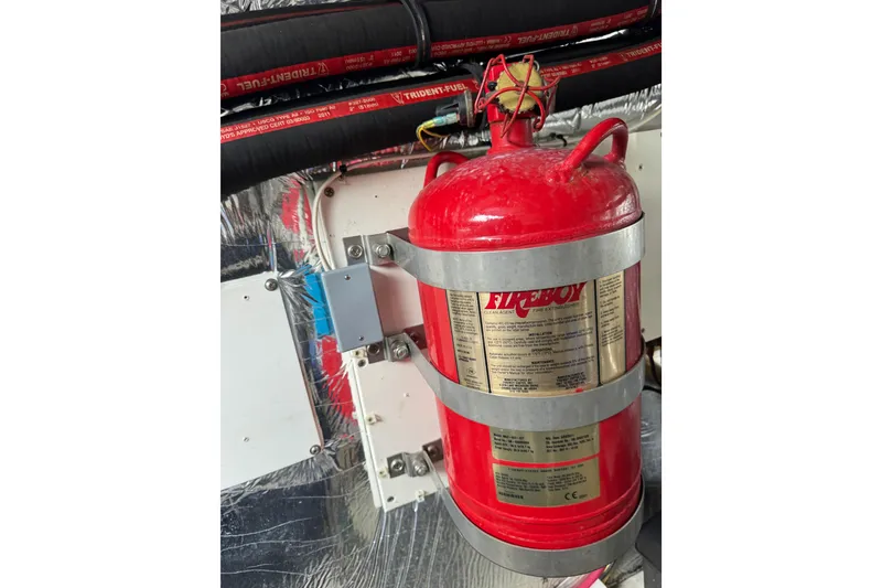 Slide: The Image of Fire extinguisher in 2012 Cruisers Yachts 48 Cantius engine room, secured with metal straps. - 58