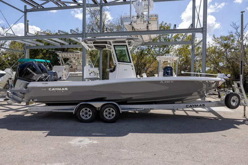 Slide: The Image of 2022 Caymas 28 HB Twin boat on trailer, parked outdoors under metal structure. - 2