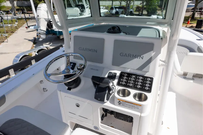 Slide: The Image of 2022 Caymas 28 HB Twin boat dashboard with Garmin displays and steering wheel. - 22