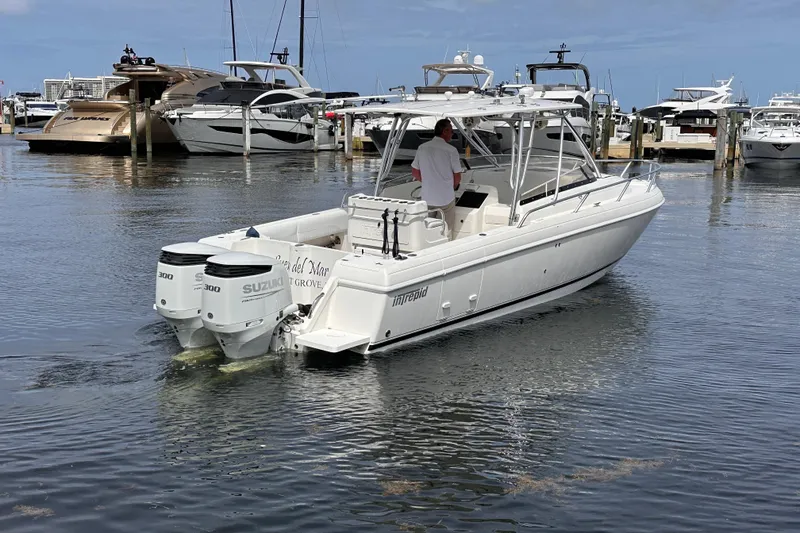 The Image of 2007 Intrepid 310 Walkaround boat with dual Suzuki engines in a marina setting. - 0