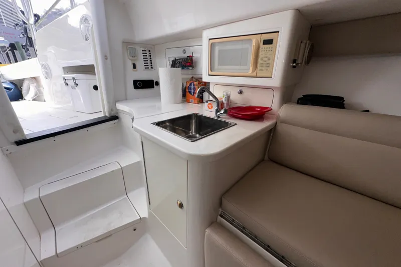 Slide: The Image of 2007 Intrepid 310 Walkaround interior with kitchenette, sink, microwave, and seating area. - 10