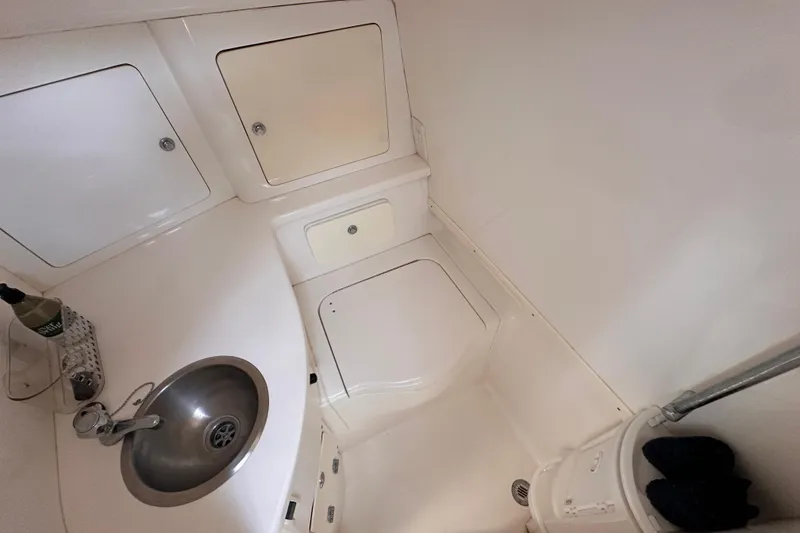 Slide: The Image of 2007 Intrepid 310 Walkaround boat interior with sink and storage compartments. - 11