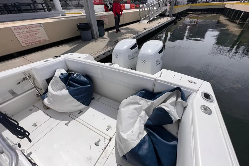 Slide: The Image of 2007 Intrepid 310 Walkaround boat with Suzuki engines docked, featuring bean bags on deck. - 16