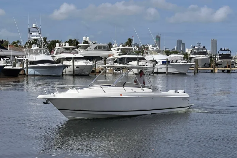 Slide: The Image of 2007 Intrepid 310 Walkaround boat cruising in a marina with yachts and city skyline. - 20