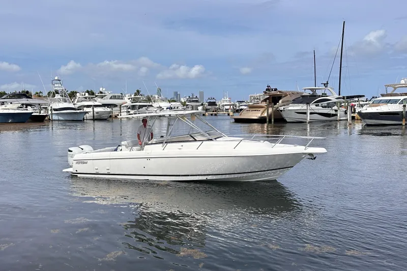 Slide: The Image of 2007 Intrepid 310 Walkaround boat docked in a marina with other yachts. - 21