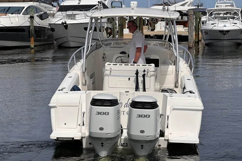 Slide: The Image of 2007 Intrepid 310 Walkaround boat with dual 300 horsepower engines docked at marina. - 25