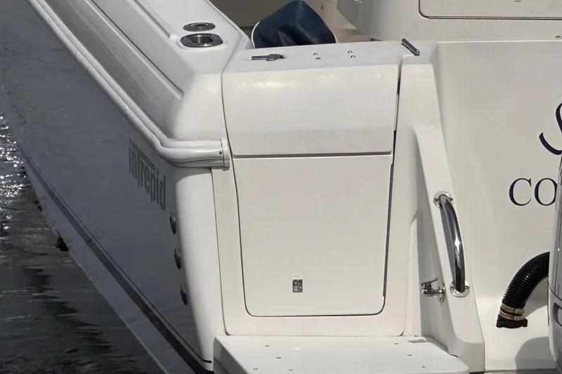 Slide: The Image of 2007 Intrepid 310 Walkaround boat stern view with sleek white design. - 26