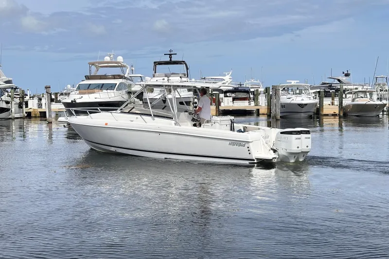 Slide: The Image of 2007 Intrepid 310 Walkaround boat docked in a marina with other vessels. - 27