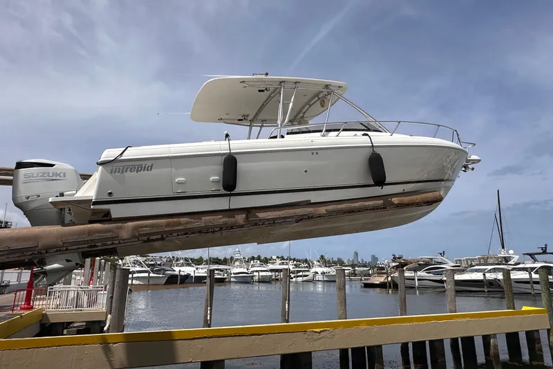 Slide: The Image of 2007 Intrepid 310 Walkaround boat on lift at marina, clear sky background. - 28