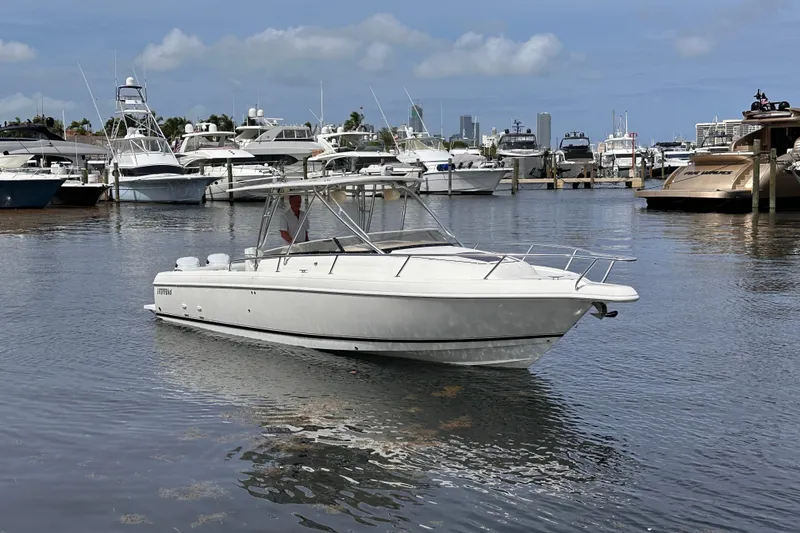Slide: The Image of 2007 Intrepid 310 Walkaround boat docked in a marina with other vessels. - 3