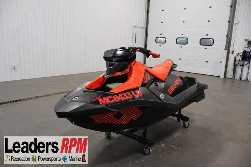 The Image of 2022 Sea-Doo Spark for 2 jet ski in a showroom, featuring vibrant red and black design. - 1