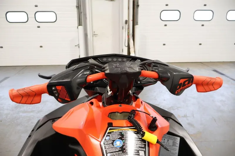 Slide: The Image of 2022 Sea-Doo Spark for 2 handlebars in a garage setting, showcasing vibrant orange grips. - 13