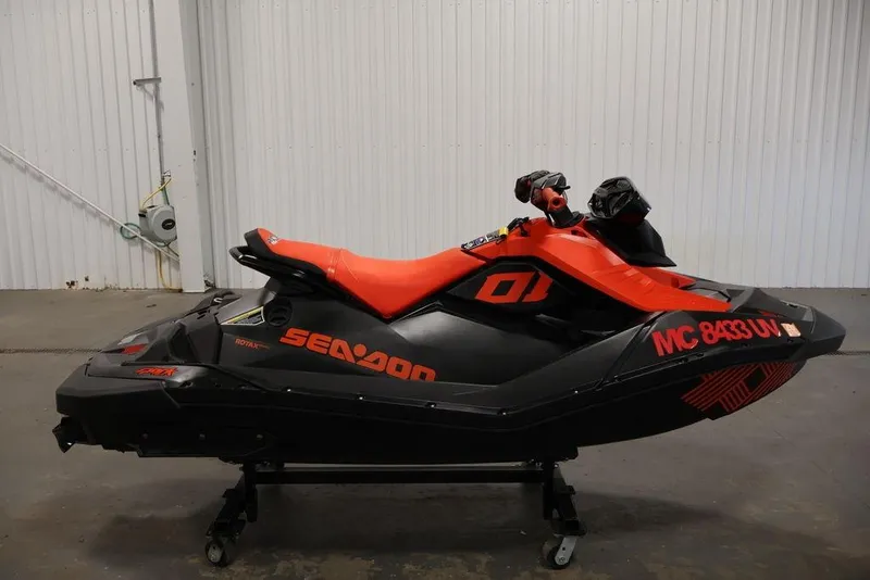 Slide: The Image of 2022 Sea-Doo Spark for 2 jet ski, black and orange, in a garage setting. - 8