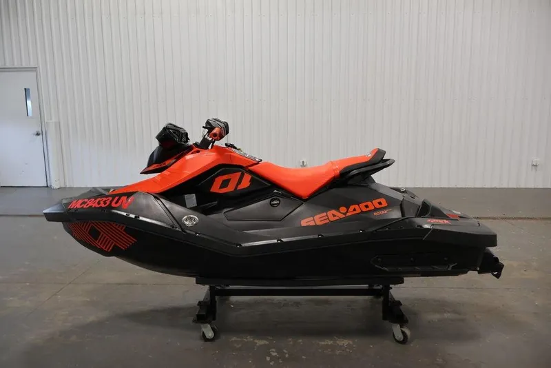 Slide: The Image of 2022 Sea-Doo Spark for 2, black and orange jet ski, side view in a garage. - 9