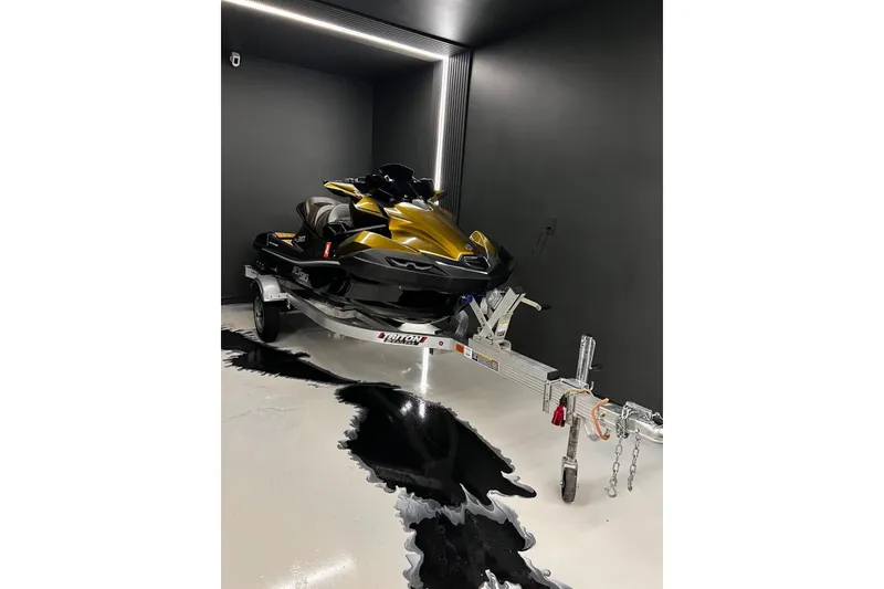 Slide: The Image of 2023 Kawasaki Jetski Ultra 310LX in sleek black and gold, parked on a trailer. - 12