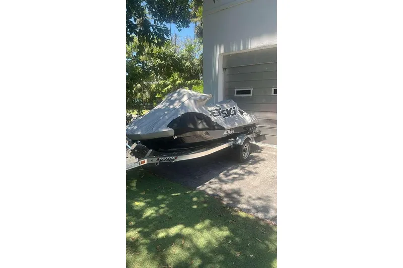 Slide: The Image of 2023 Kawasaki Jetski Ultra 310LX covered and parked on a trailer in a driveway. - 14