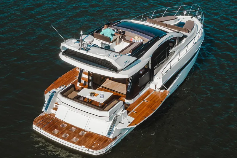 Slide: The Image of 2024 Galeon 470 Sky yacht cruising on water, showcasing luxurious deck and seating area. - 2
