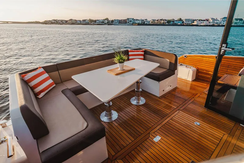 Slide: The Image of Luxurious 2024 Galeon 470 Sky yacht deck with seating, table, and scenic water view. - 5