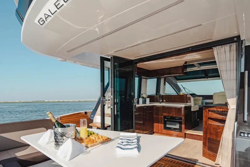 Slide: The Image of 2024 Galeon 470 Sky yacht interior with dining setup and ocean view. - 6