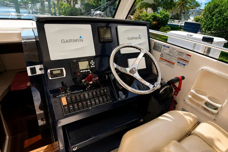 Slide: The Image of 2016 Pursuit OS 325 Offshore boat cockpit with Garmin navigation system and steering wheel. - 12