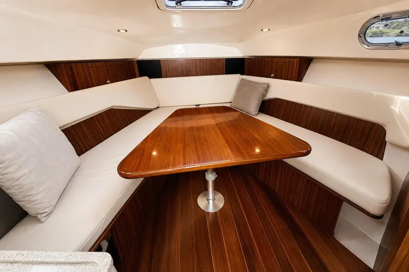 Slide: The Image of Luxurious interior of 2016 Pursuit OS 325 Offshore boat with wooden table and seating. - 15