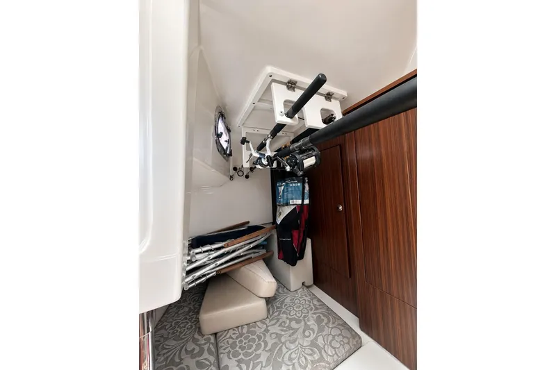 Slide: The Image of 2016 Pursuit OS 325 Offshore cabin interior with fishing rod storage and wooden cabinetry. - 16