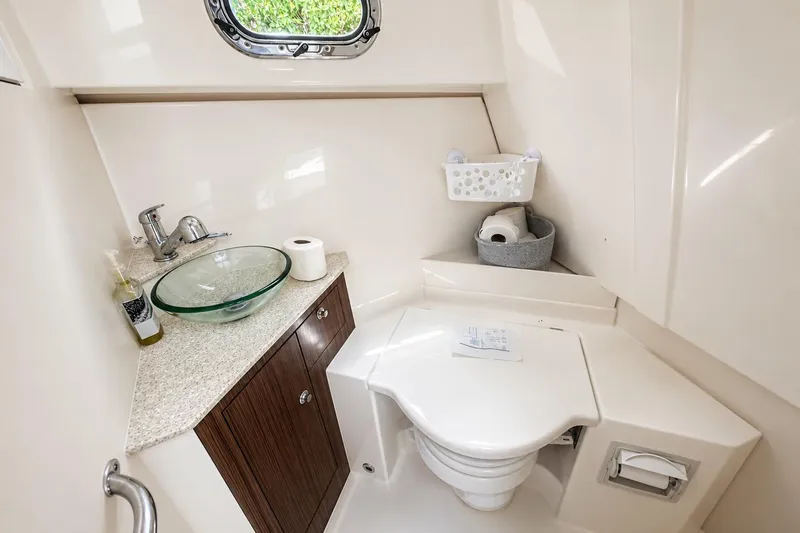 Slide: The Image of 2016 Pursuit OS 325 Offshore boat bathroom with modern sink and toilet. - 17