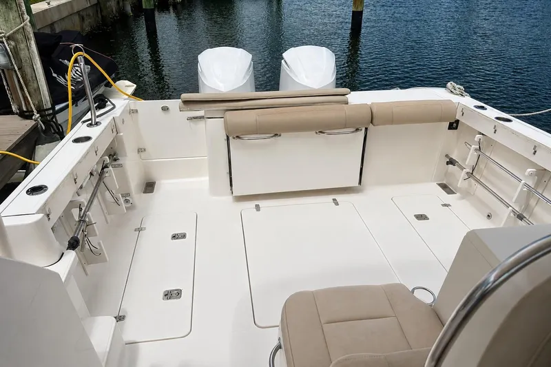 Slide: The Image of 2016 Pursuit OS 325 Offshore boat deck with seating and storage, docked by the water. - 5