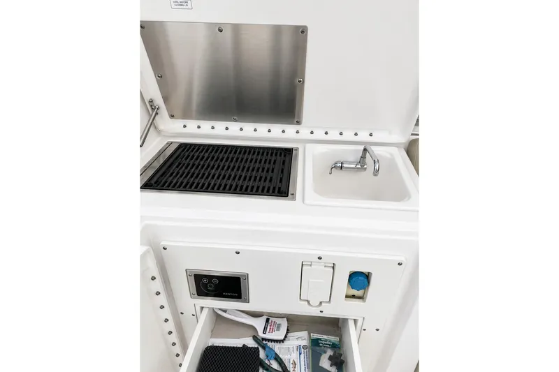 Slide: The Image of 2016 Pursuit OS 325 Offshore boat galley with grill, sink, and storage. - 7