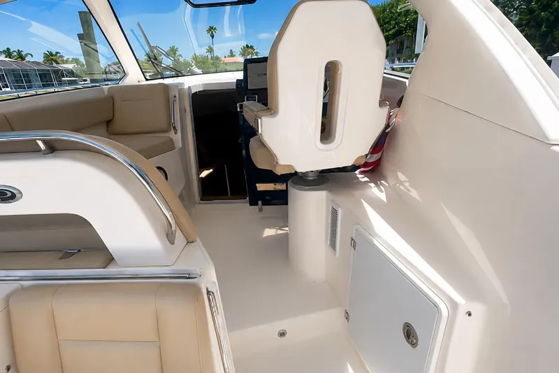 Slide: The Image of 2016 Pursuit OS 325 Offshore boat interior with beige seating and helm station. - 8